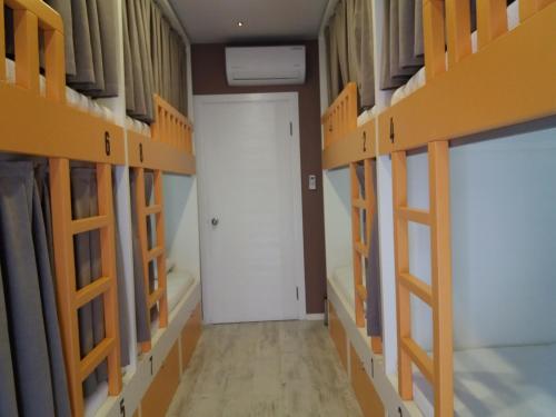 a room with rows of bunk beds with a white door at Sakura Hostel Fethiye in Fethiye