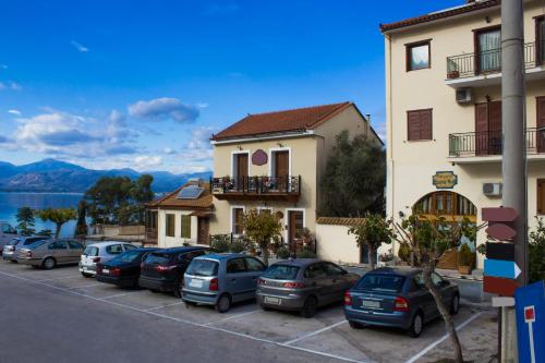 a row of cars parked in a parking lot next to a building at Bonne Nuit Pension in Nafplio