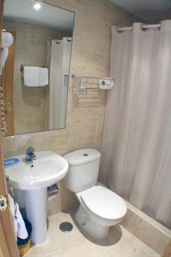 a bathroom with a white toilet and a sink at Hostal Santa Cruz in Madrid