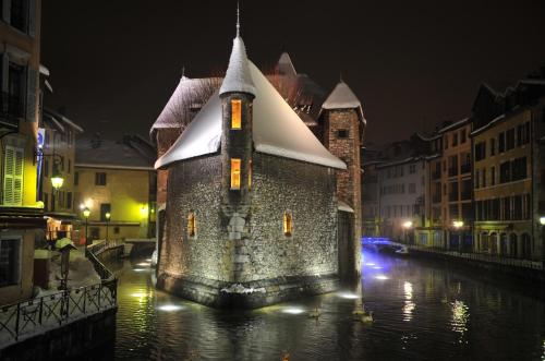 a building in the middle of a river at night at Les suites sainte claire in Annecy