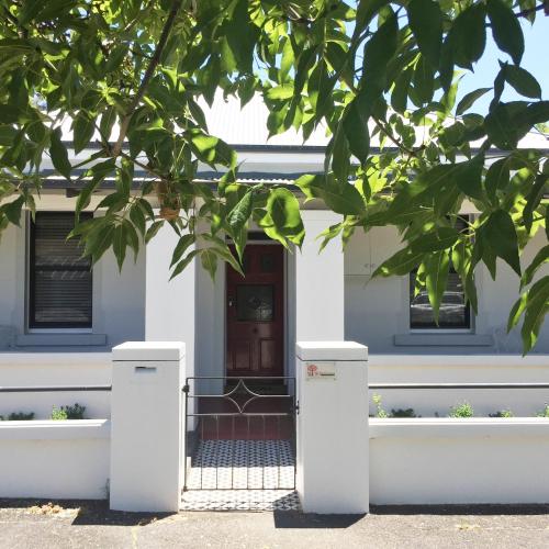 a blue and white house with a door at 99 Hill Street Apartments in Orange
