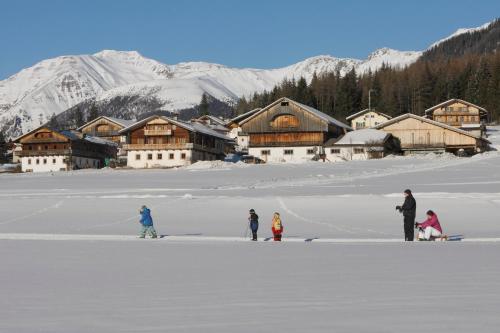 a group of people standing in the snow in front of a lodge at Mudlerhof in Prateria