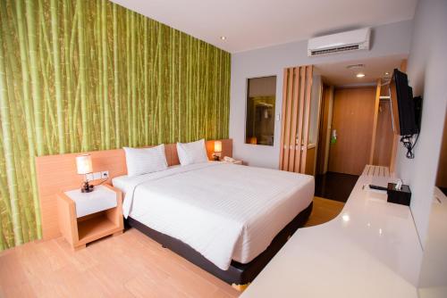 1 dormitorio con 1 cama grande y TV en Happy Inn, en Yakarta