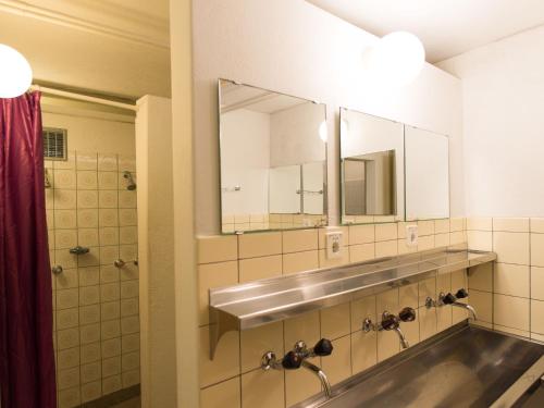 a bathroom with a sink and a mirror at Gasthaus Pension zum Turm in Hospental