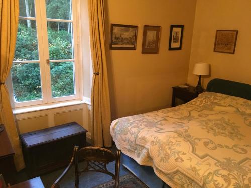 a bedroom with a bed and a window at Chateau de Beaulieu in Saint-Sauveur-le-Vicomte