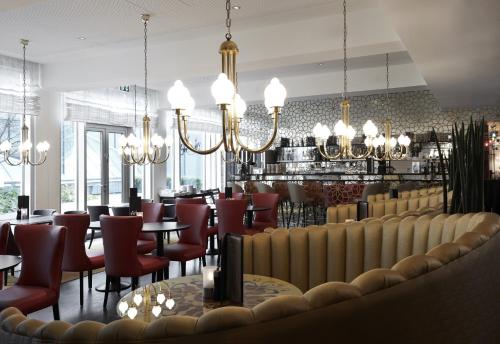 ein Restaurant mit Tischen, Stühlen und Kronleuchtern in der Unterkunft Tivoli Hotel in Kopenhagen