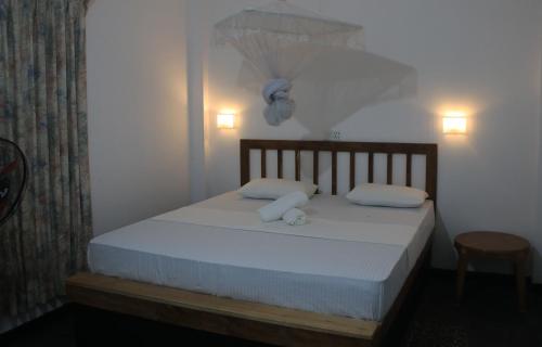 a bedroom with a bed with white sheets and pillows at City- in Safari Resort in Udawalawe