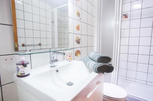 ein Badezimmer mit einem Waschbecken, einem WC und einem Spiegel in der Unterkunft Apartamento con ascensor Gran Tarajal Playa in Gran Tarajal
