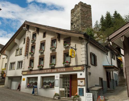 a building with flowers on the windows of it at Gasthaus Pension zum Turm in Hospental