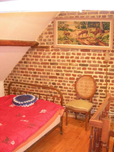 une chambre avec un lit et un mur de briques dans l'établissement La Fermette de la Vache Rousse, à Rosult