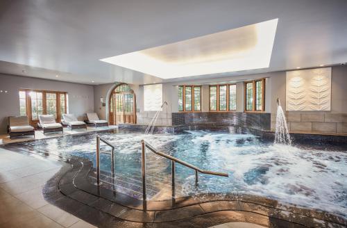 a large swimming pool with a fountain in a building at Mallory Court Country House Hotel & Spa in Leamington Spa
