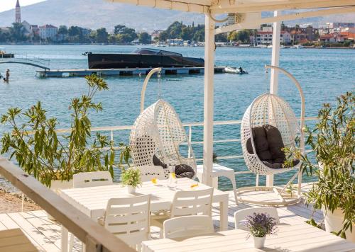 a table and chairs on a pier next to the water at Hotel Brown Beach House & Spa in Trogir