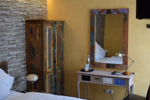 a bedroom with a mirror and a bed and a table at Hotel Arte Vida OHG in Spremberg