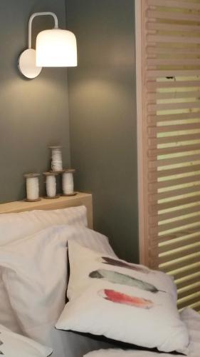 a bed with a white pillow and a lamp at Hostellerie Les Bagenelles in Sainte-Marie-aux-Mines