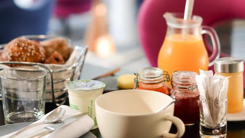 a table with a cup of coffee and a plate of food at Le Central Boutique Hôtel in Beaune