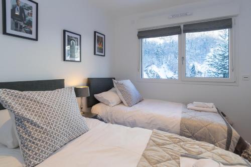 a bedroom with two beds and a window at La Niche in Brides-les-Bains