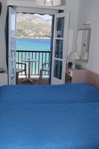 a bedroom with a bed and a view of the ocean at Lemos Hotel in Kokkari