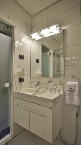 a white bathroom with a sink and a mirror at Monte Mare Hotel in Jounieh
