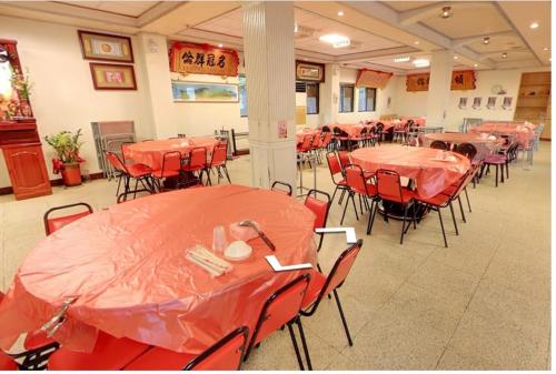 a room with tables and chairs with red tables at Dong Bi Villa in Gukeng
