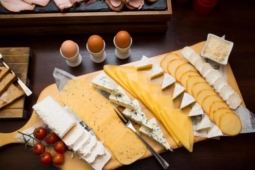 a table topped with cheese and meats and eggs at Hotel & Restauracja Gniecki in Hrubieszów