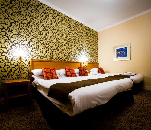 a hotel room with two beds and a wall at Best Western Queens Hotel in Dundee