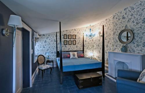 a bedroom with a blue bed and a fireplace at Talayar Valley Bungalow in Idukki