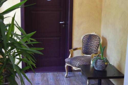 a chair and a table in front of a door at Hotel Arte Vida OHG in Spremberg