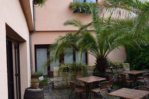 an outdoor patio with tables and chairs and palm trees at Hotel Arte Vida OHG in Spremberg