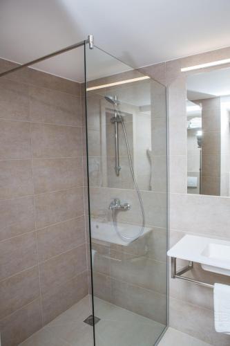 a shower with a glass door in a bathroom at Ukraina Hotel in Cherkasy