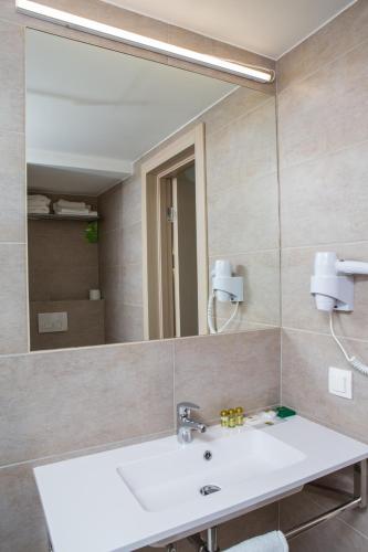 a bathroom with a sink and a large mirror at Ukraina Hotel in Cherkasy