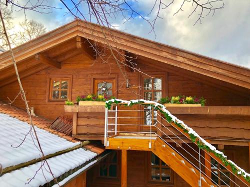 a log cabin with a staircase in front of it at Landhaus de Gaspary in Seehausen am Staffelsee