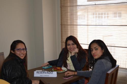 three women sitting at a table with a plate of food at Hotel San Agustin Plaza in Latacunga
