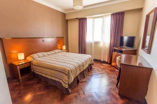 a hotel room with a bed and a television at Hotel Dorá in Mar del Plata