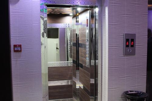 فندق سما في الرياض: حمام مع دش مع مرآة والجدران الأرجوانية