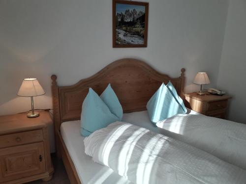a bedroom with a bed with blue and white pillows at Reschnerhof in Resia