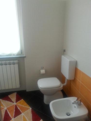 a bathroom with a white toilet and a sink at Zia Zelinda in Dego