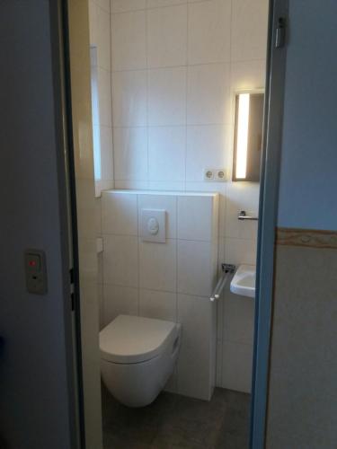 a small bathroom with a toilet and a sink at Gästehaus Wagner in Grainau