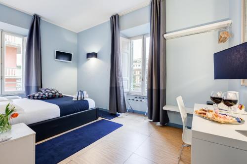 a hotel room with a bed and a table with wine glasses at Easy Budget Colosseo in Rome