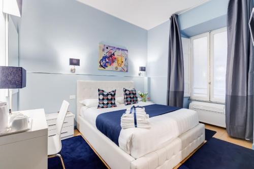 a bedroom with a white bed and a desk at Easy Budget Colosseo in Rome