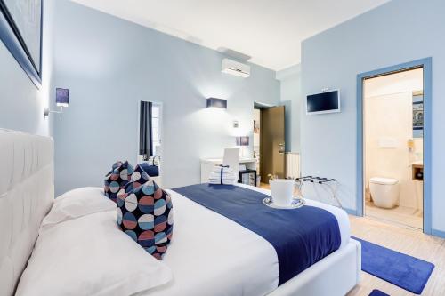 a bedroom with a large white bed and a bathroom at Easy Budget Colosseo in Rome