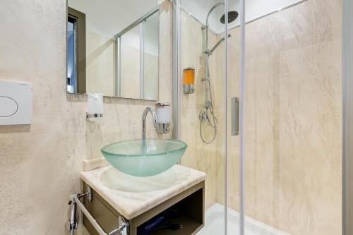 a bathroom with a glass bowl sink in a shower at Easy Budget Colosseo in Rome