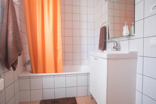 an orange shower curtain in a bathroom with a sink at Apartamento con ascensor en primera línea in Gran Tarajal