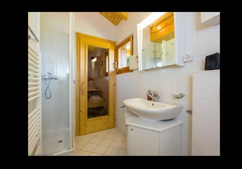 a white bathroom with a sink and a shower at Chalet Clochette 4 Valles-Verbier in La Tzoumaz