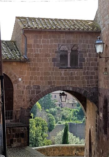 an archway in a brick building with a view at Tuscania Terme Suites Apartments in Tuscania