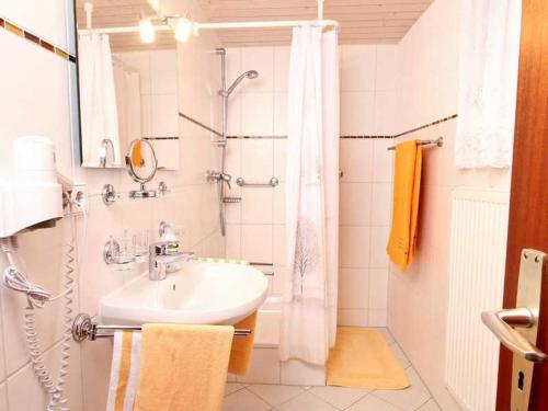 ein weißes Bad mit einem Waschbecken und einer Dusche in der Unterkunft Ferienwohnung Nain in Bad Dürrheim