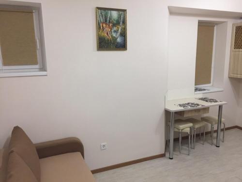 a living room with a table and a painting on the wall at Polyana Apart in Polyana