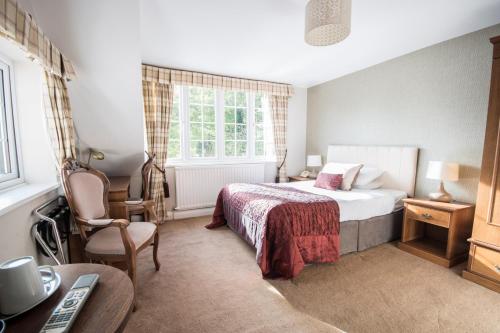 1 dormitorio con cama, silla y escritorio en The Mill House en Reading