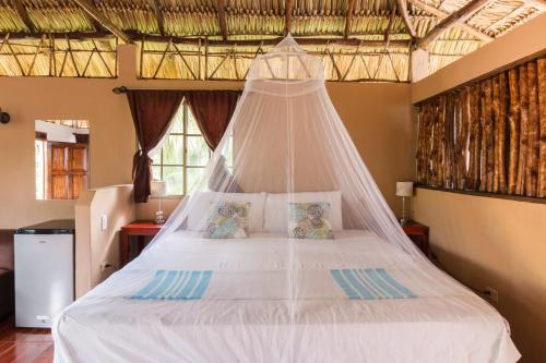 a bedroom with a bed with a mosquito net at Hotel Mariposa in León