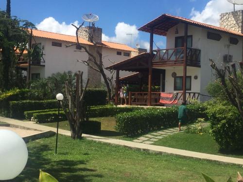 a person walking in front of a house at Casa de Luxo com 3 Suites no Condominio Horizonte da Serra 1 em Gravatá in Gravatá