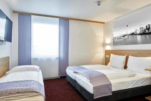 Ένα ή περισσότερα κρεβάτια σε δωμάτιο στο McDreams Hotel Düsseldorf-City